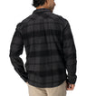 Back view of man wearing Reggie Flannel Shirt in dark plaid, showcasing comfort-focused surf-inspired apparel.