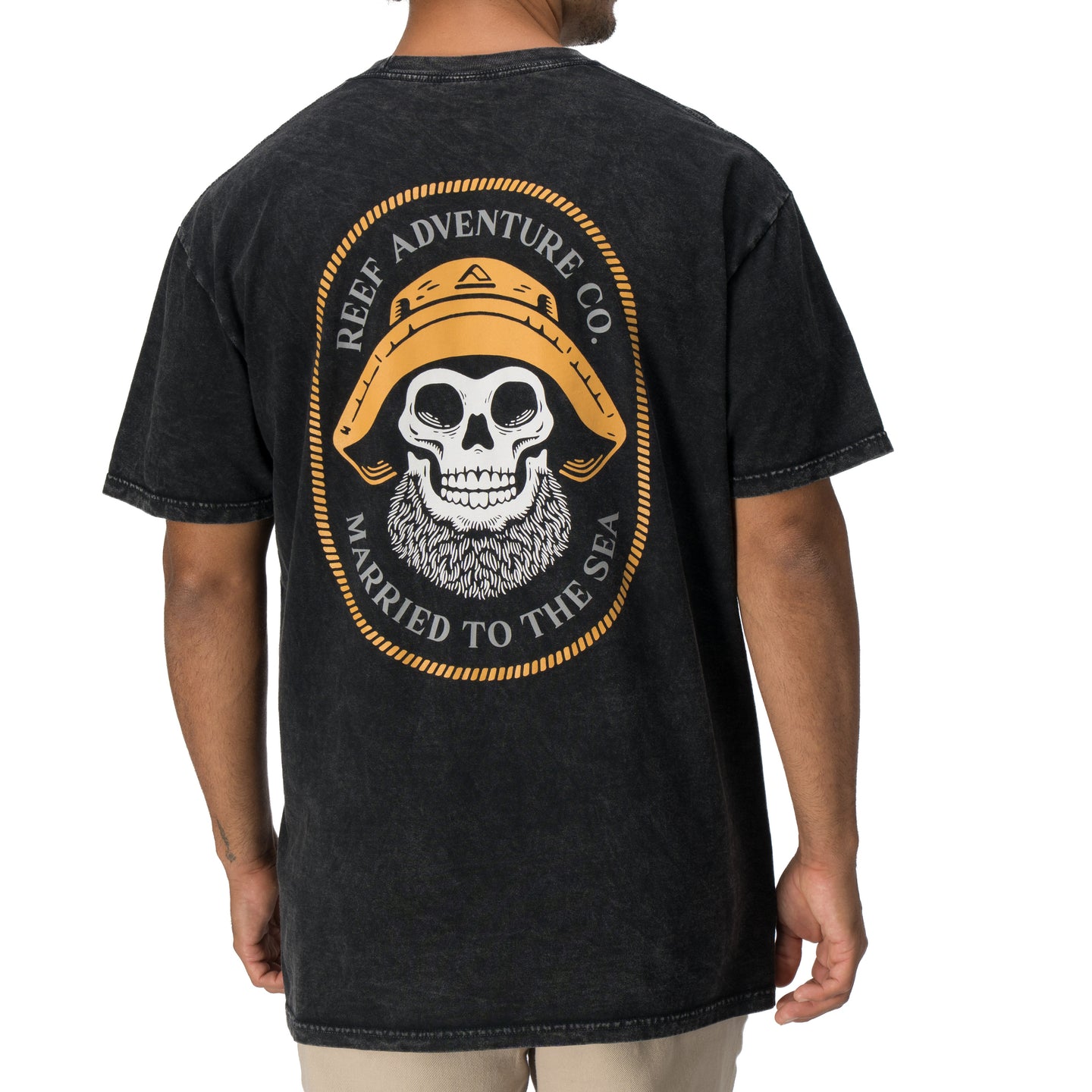 Back view of a man wearing a black Salty Short Sleeve Tee featuring vintage skull and hat artwork, coastal style apparel.