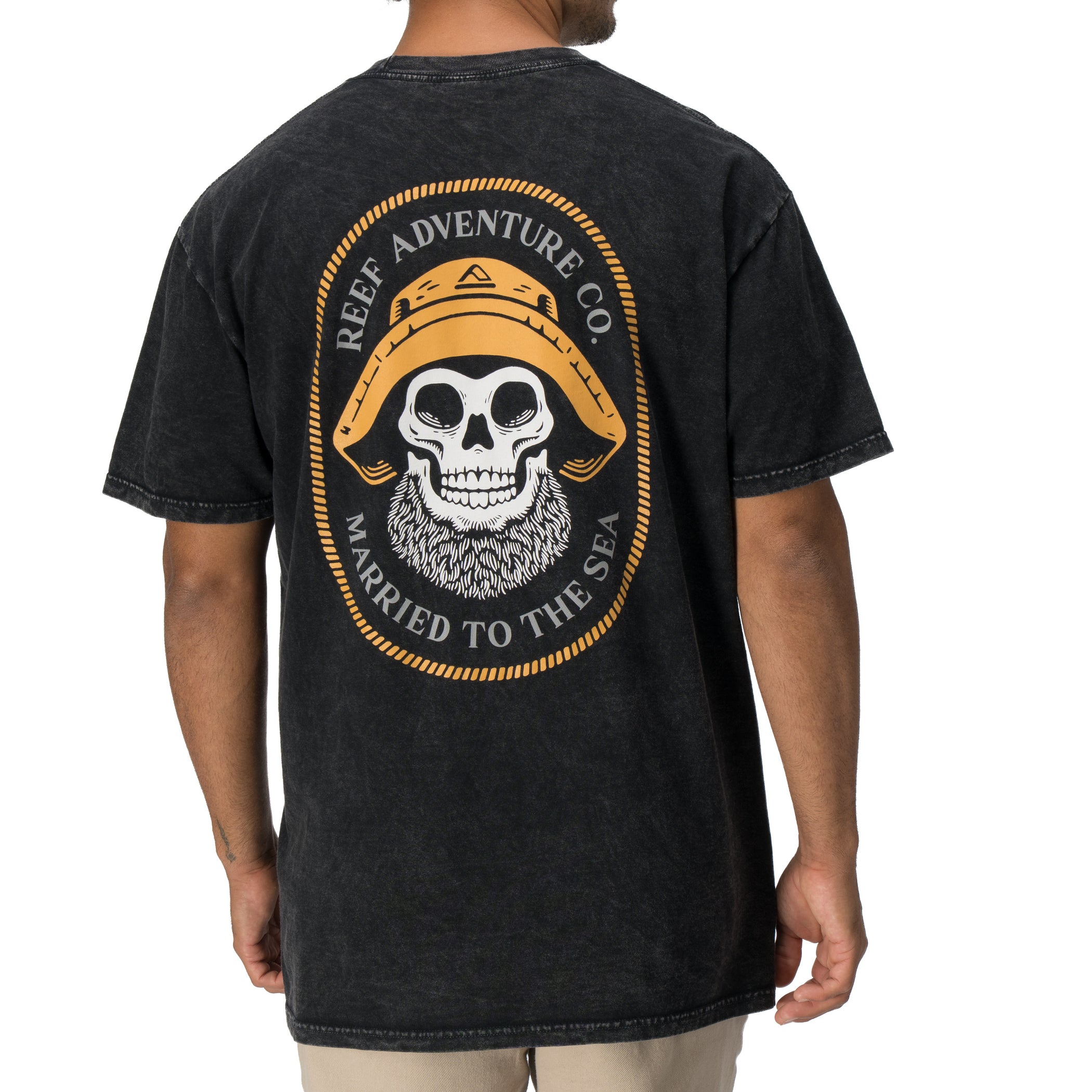 Back view of a man wearing a black Salty Short Sleeve Tee featuring vintage skull and hat artwork, coastal style apparel.