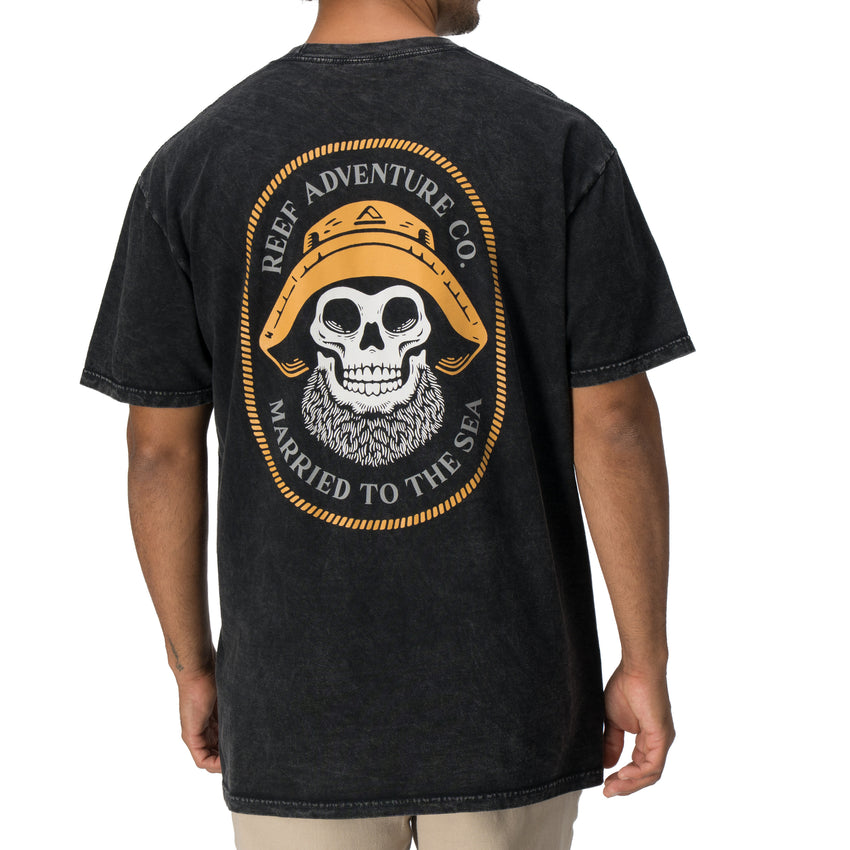 Back view of a man wearing a black Salty Short Sleeve Tee featuring vintage skull and hat artwork, coastal style apparel.