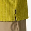 Close-up of the hem and side slit of the Myran Camp Shirt in olive green, highlighting textured ribbed fabric.