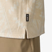 Close-up of the lower side hem of the Novak Camp Shirt in beige terry fabric with REEF label, showcasing beach-inspired comfort.