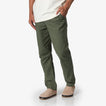 Front view of men's Matthew Twill Pant in olive green paired with beige slip-on shoes, highlighting beach-inspired comfort.