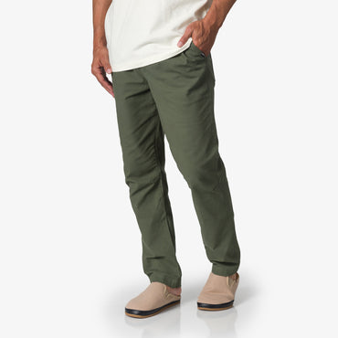Front view of men's Matthew Twill Pant in olive green paired with beige slip-on shoes, highlighting beach-inspired comfort.