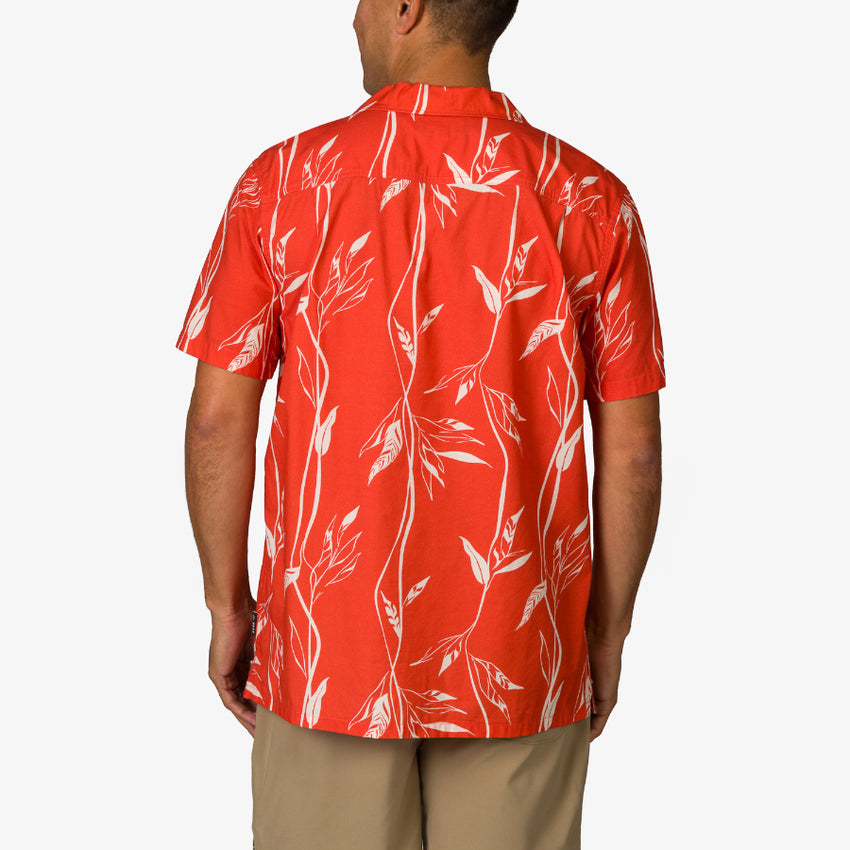 Back view of the Kaden Camp Shirt on a man, featuring red fabric with white leaf patterns, beach-inspired comfort design.