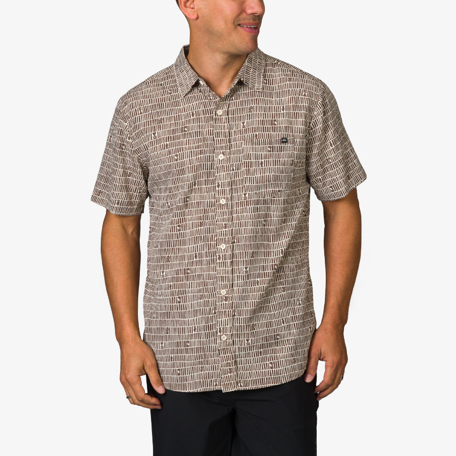 Man wearing Ferris Classic Shirt with beige geometric pattern, front view, styled for beach comfort and active lifestyle.