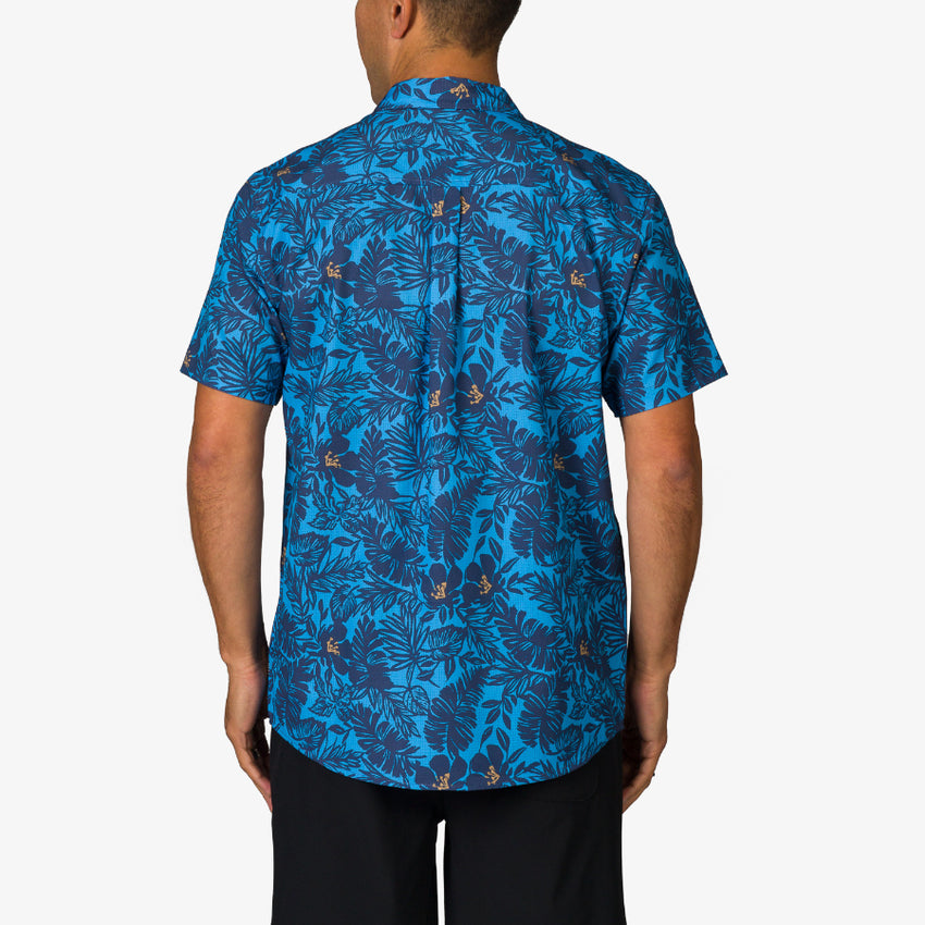 Man wearing Tyson Classic Shirt showing back view with blue tropical leaf pattern, beach-inspired comfort apparel for men.