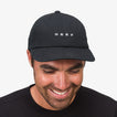Front view of a man wearing a black Schotts Twill Hat with REEF logo, showcasing beach-inspired comfort and style.