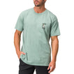 Front view of a man wearing a green Akin Tee with a small palm tree graphic, surf-inspired casual apparel for men.