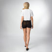 Woman wearing Night Surf Crop Crew Tee, shown from the back, walking in black REEF sandals facing away from the camera.