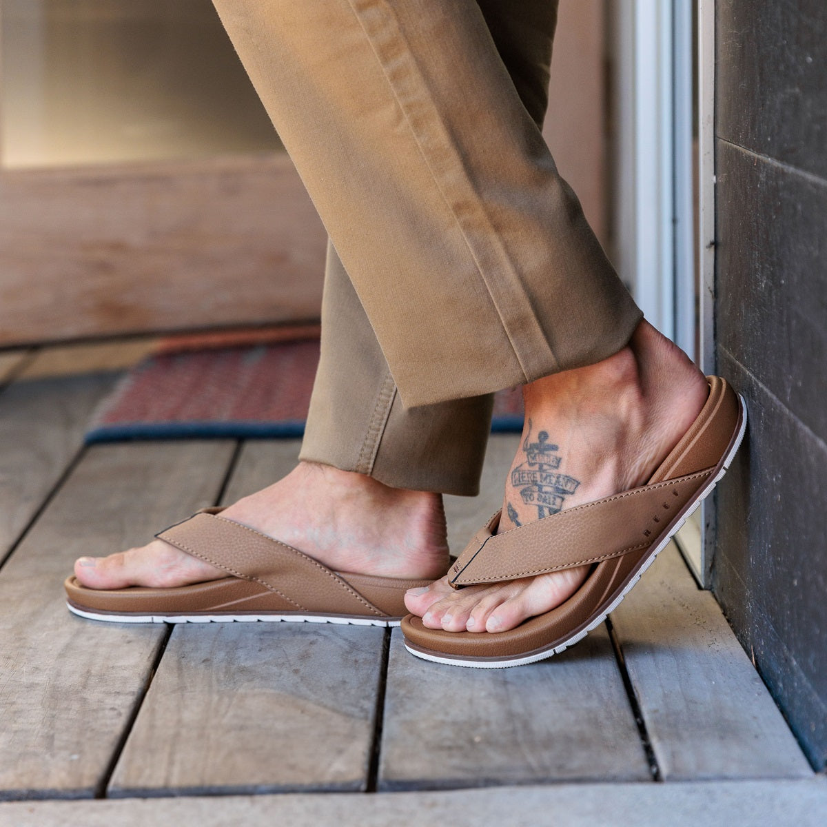 Side view of men's Phantom Bonzer sandals in tan, showing comfortable cushioning and arch support on wooden floor.