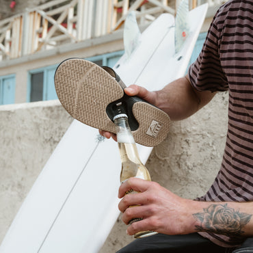 Fanning men's sandal showing sole facing upward with bottle opener feature, highlighting comfort and surf-inspired design