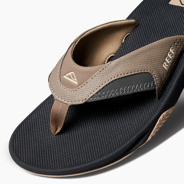 Fanning men’s sandal facing left, close-up of toe post and upper strap with anatomical arch support and soft cushioning.
