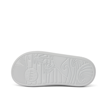 Kids Rio Slide outsole facing up showing textured beach-inspired sole with palm tree and wave patterns in light grey