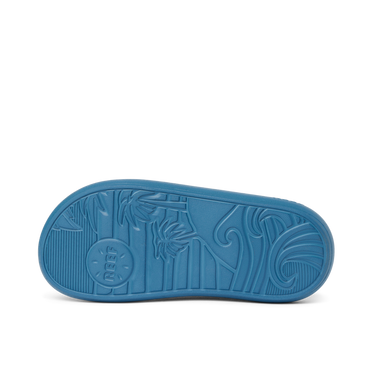 Kids Rio Slide showing the bottom sole facing up with surf-inspired wave and palm tree tread pattern in navy blue rubber