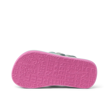 Little Ahi girls’ sandal showing bottom sole facing up with pink textured REEF logo pattern, beach comfort design.