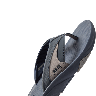 Right side view of Fanning + men's sandal showing navy and grey straps with REEF logo and cushioned footbed