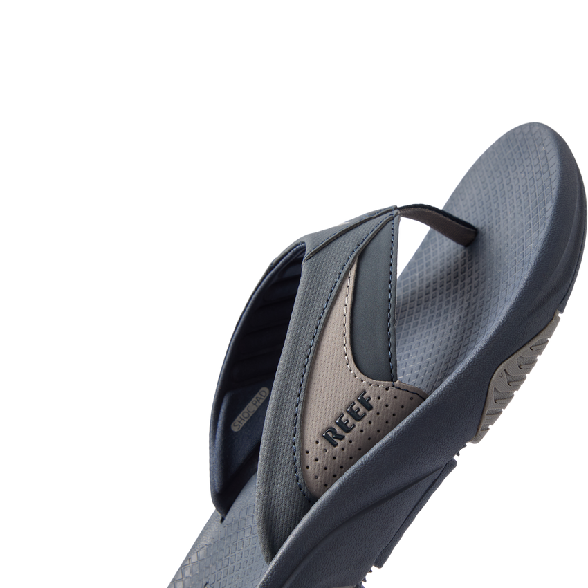 Right side view of Fanning + men's sandal showing navy and grey straps with REEF logo and cushioned footbed