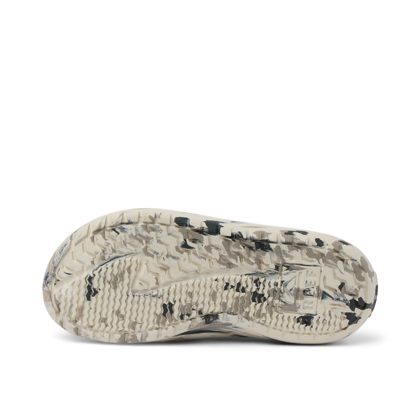 Glider sandal outsole facing up with textured tread in beige and black, showing durable water-friendly sole design