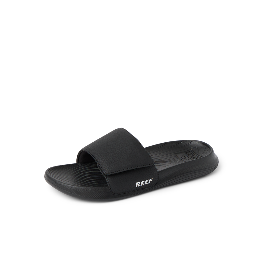 Kids Salty Slide in black facing left, close-up of the top and side showing cushioned footbed and adjustable strap.