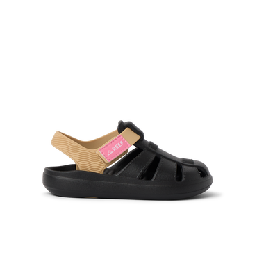Little Totally Beachin black and tan girls’ sandal facing right, featuring soft cushioning and anatomical arch support.