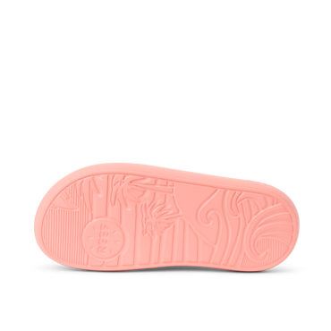 Kids Rio Slide coral outsole facing up, showing textured grip with surf-inspired patterns and Reef branding.