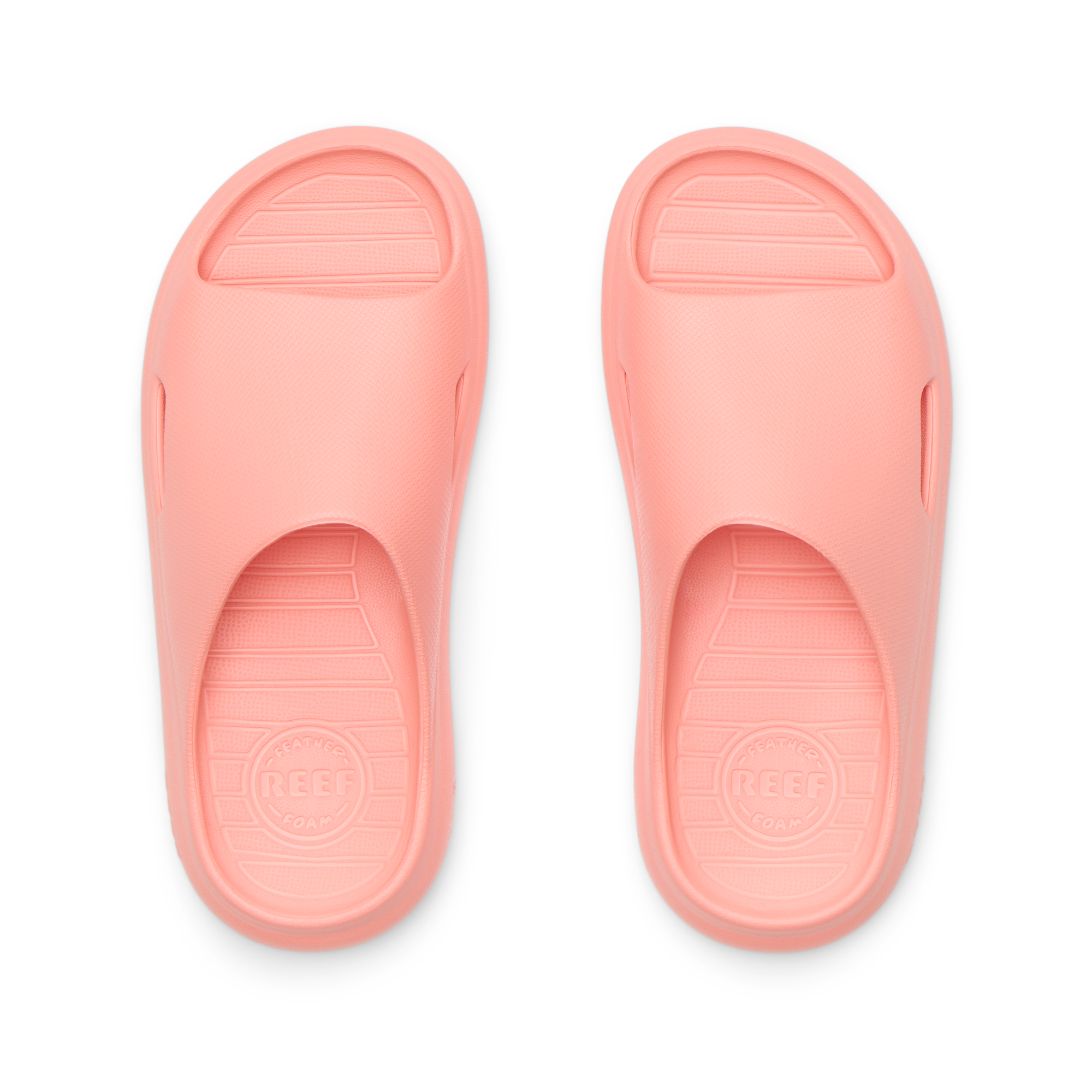 Top view of coral Kids Rio Slide unisex sandals showing molded footbed and soft-rebound cushioning for beach comfort