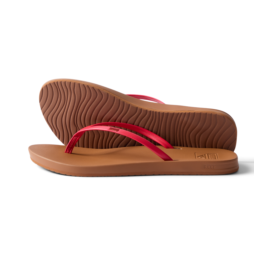Pair of Cushion Slim women's sandals facing right, side and sole view, red straps, beach-inspired water-friendly design.