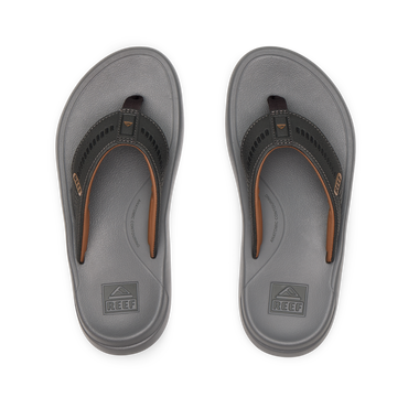 Top-down view of men's Cruiser flip flops in raven gray and brown, featuring anatomical arch support and soft cushioning.