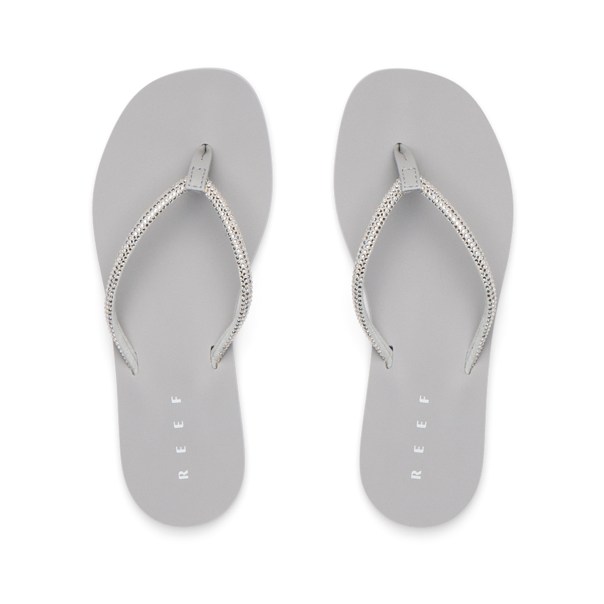 Bliss Bling Fling silver women's flip flops facing up, featuring surf-inspired comfort and soft cushioning for the beach.