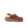 Side view of right-facing brown slip-on clog with adjustable strap and thick cushioned sole on black background