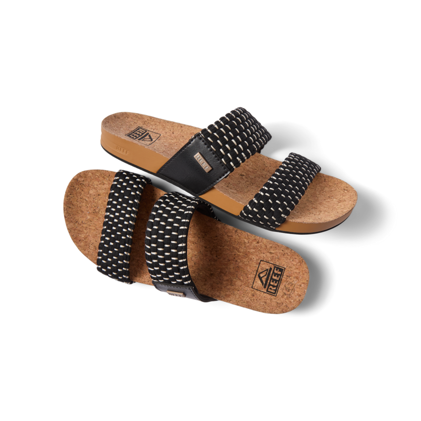 Pair of Cushion Vista women's sandals with black textile straps and cork footbed, right sandal facing left, top view close-up.