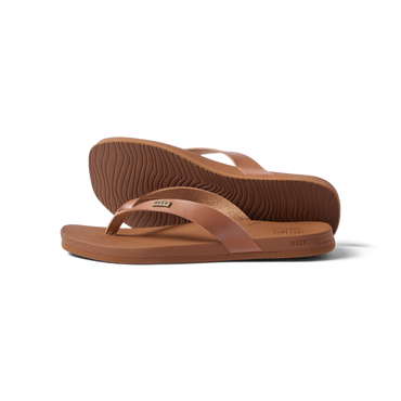 Vista Lune women's tan flip flops facing right, close-up on sole and strap, beach-inspired comfort and arch support sandals.