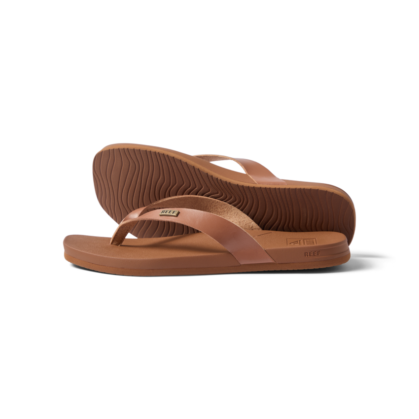 Vista Lune women's tan flip flops facing right, close-up on sole and strap, beach-inspired comfort and arch support sandals.
