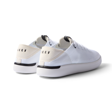 Reef Neptune white and black women's sneaker facing back right, featuring anatomical arch support and soft cushioning.