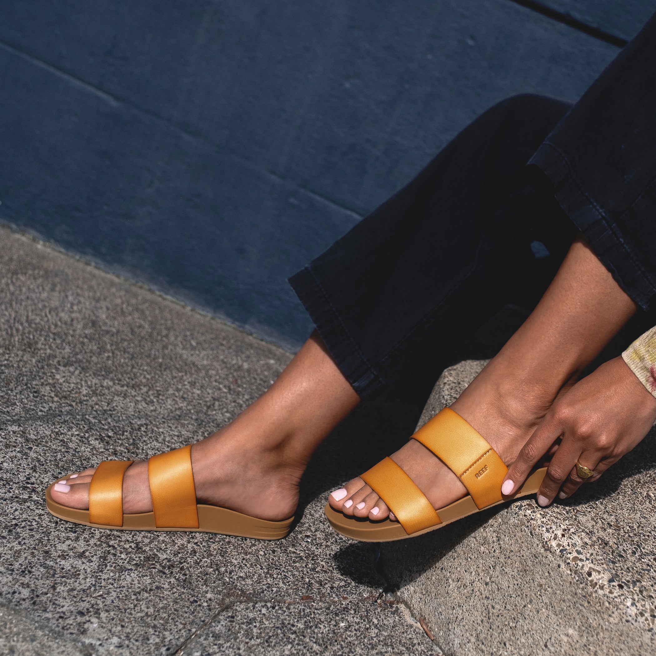 Cushion Vista sandals in tan, worn on feet facing left, showcasing lightweight, arch support beach-inspired design.