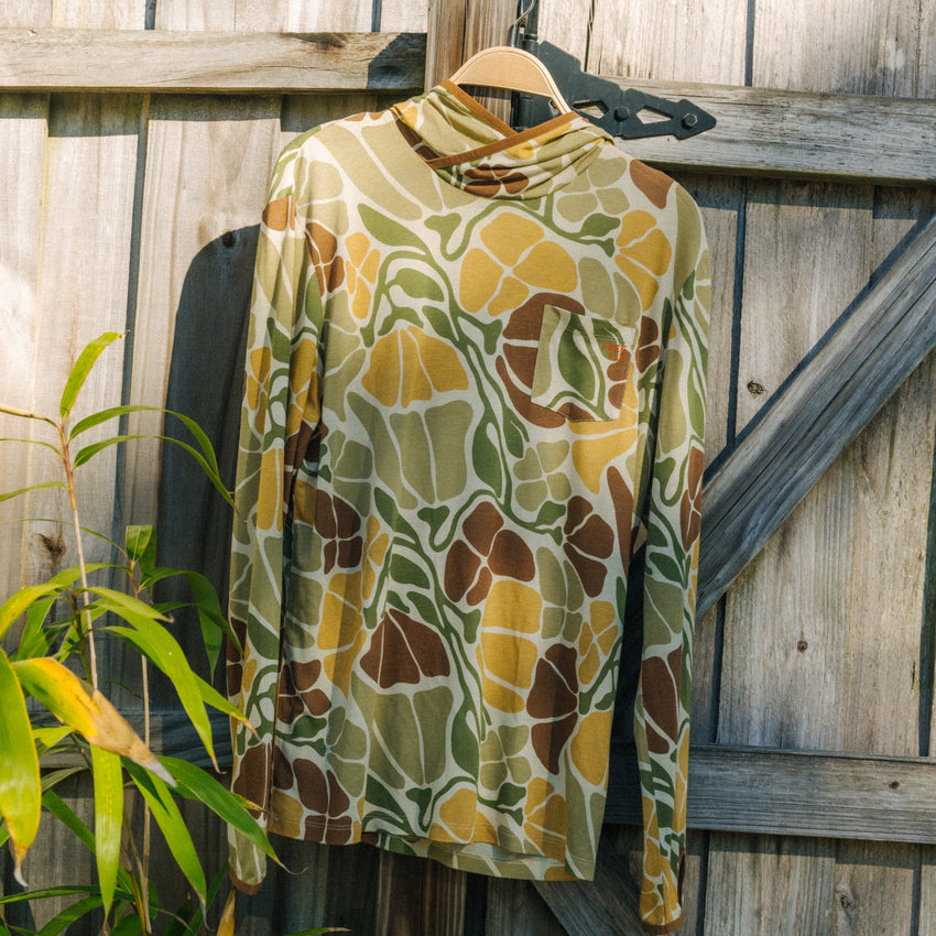 Men's Bamboo Lightweight Hoodie - Floral Camo hanging on wooden fence, lightweight breathable fabric, surf-inspired comfort design