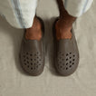 Top-down view of feet wearing brown Glider slides facing forward, showcasing water-friendly perforated toes and seamless comfort design.
