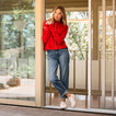 Lay Day Lite white slip-on sneakers facing forward on a model wearing jeans and a red sweater