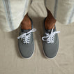 Top-down view of feet wearing grey Neptune Lido sneakers facing forward with white laces, showcasing lightweight, cushioned comfort.