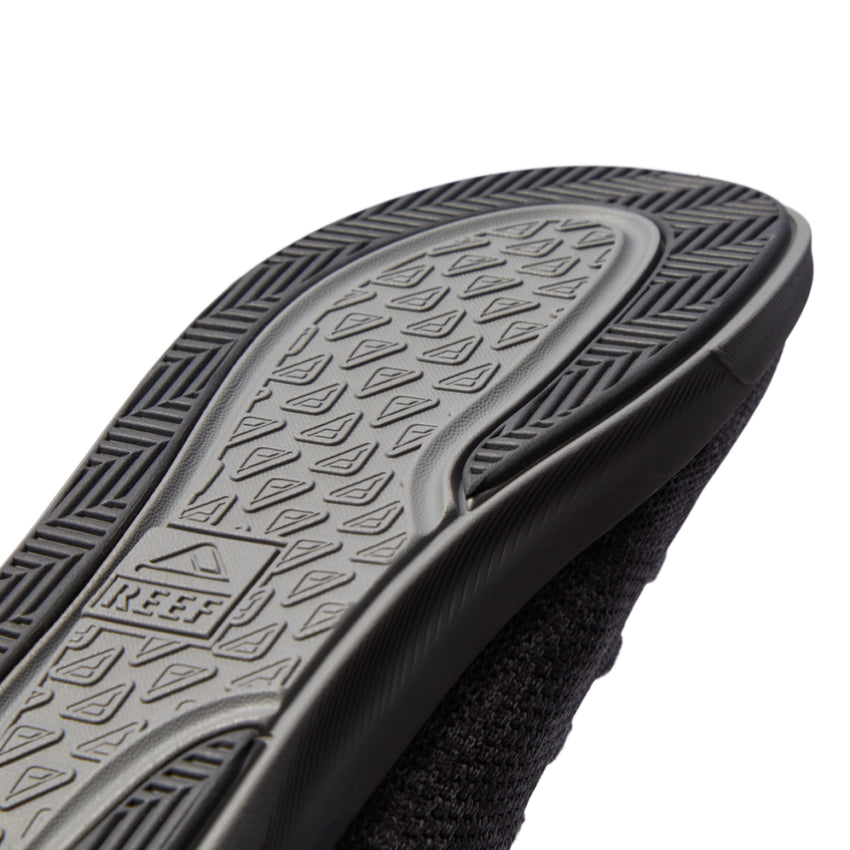 Close-up of the Neptune HT sole facing up showing durable textured tread and REEF logo with extra cushioning and arch support features.