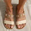 Cushion Vista sandals facing forward, tan with seashell embellishments, showing top and straps in close-up on feet.