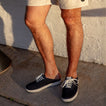 Men's feet wearing navy Neptune Lido sneakers facing forward, showcasing lightweight, comfortable beach-inspired footwear.