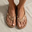 Vista Luxe Vivianahh tan sandals on feet, front view, featuring shell and starfish embellishments for beach comfort.