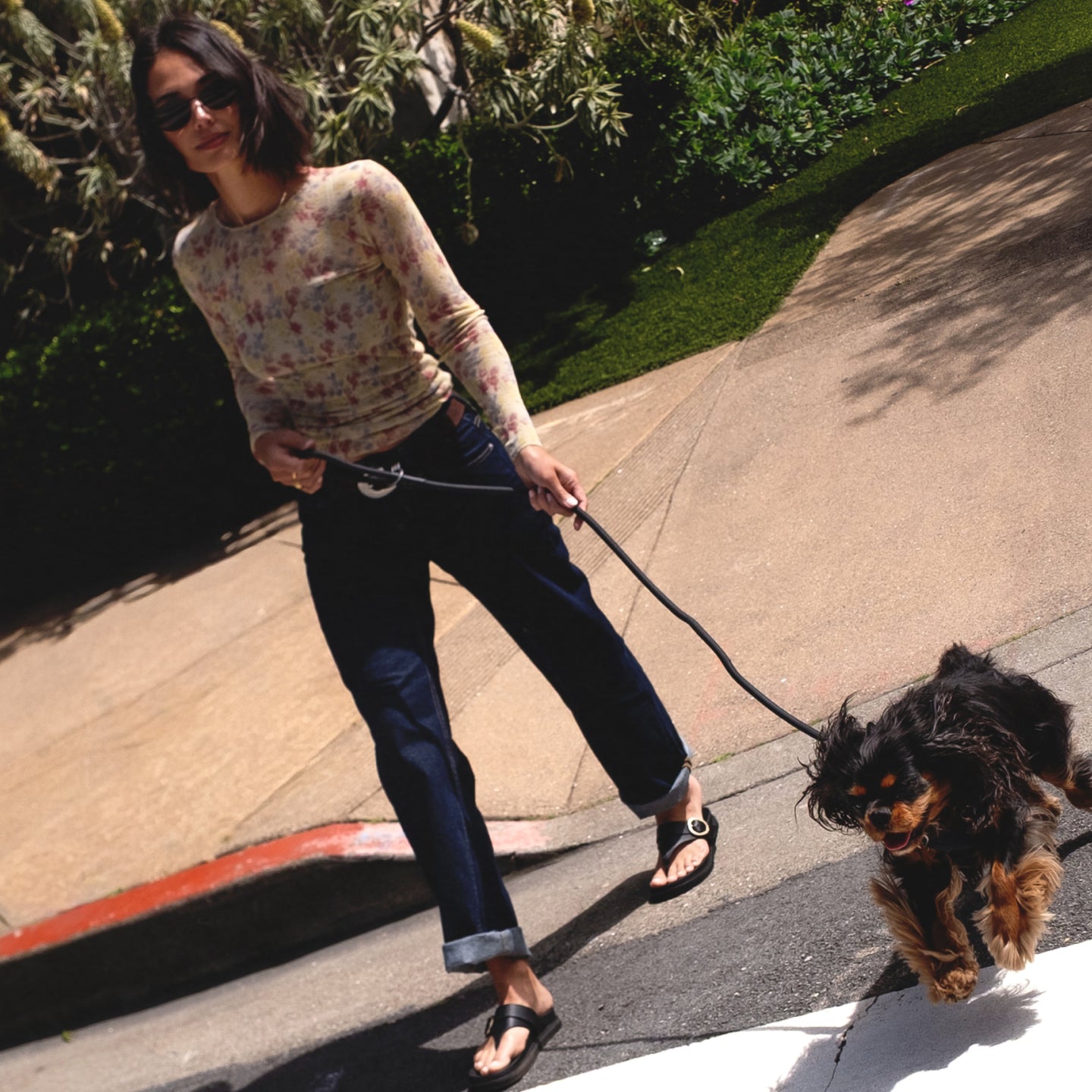 Woman wearing black Vista Gabriella sandals facing left walking dog, showcasing lightweight, arch support style for everyday casual comfort.