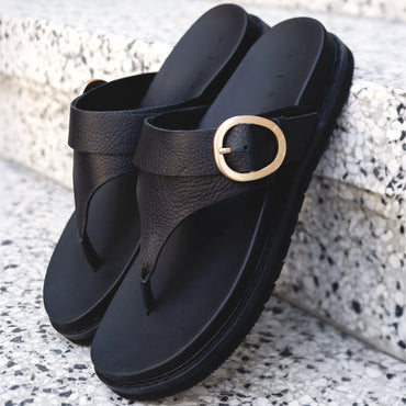 Vista Gabriella black slip-on sandals facing forward, showing buckle detail, arch support, and cushioned footbed close-up.