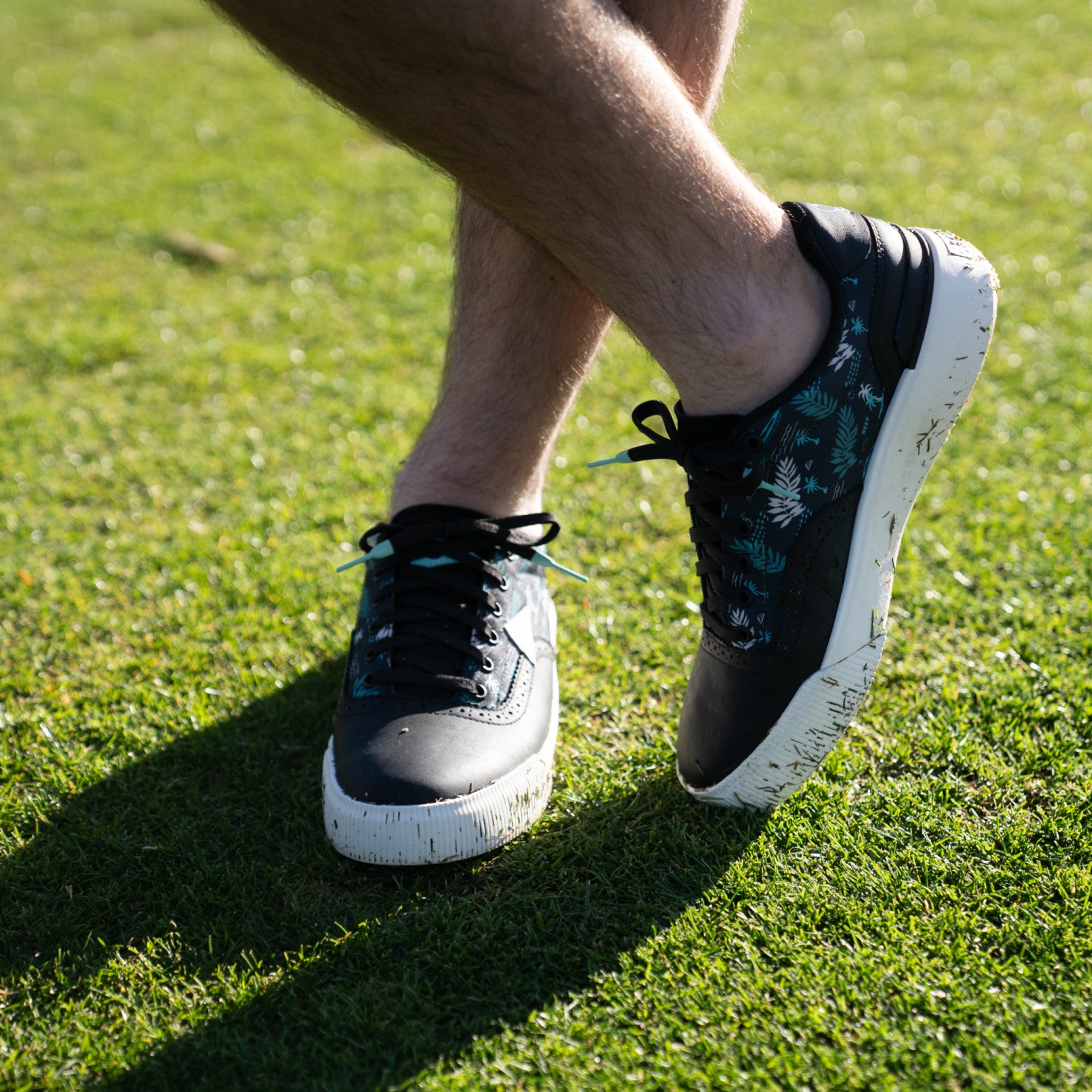 Onshore Pebble X Palm men's shoes facing right, showing top and side with floral pattern, on grass outdoors