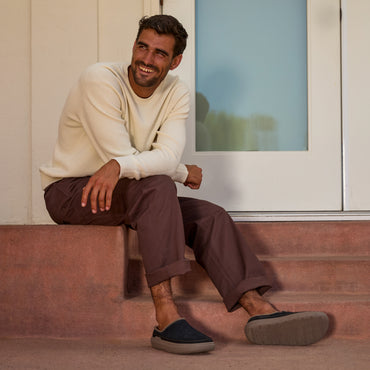 Rambler Mule black mens slip on shoe facing right worn by a seated man with cushioned comfort