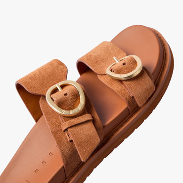 Vista Daphne slide sandal facing right, close-up of sculpted suede straps with gold adjustable buckles