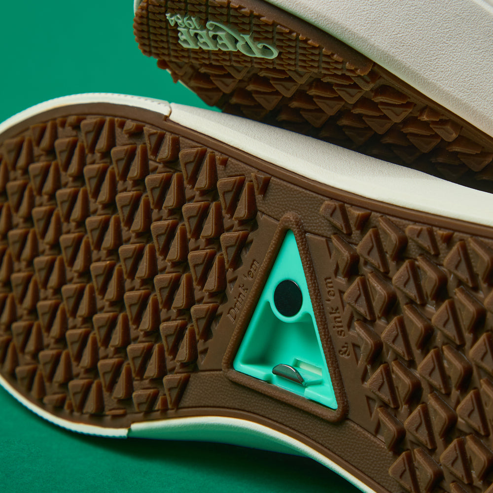 Close-up of the outsole of Onshore Pebble X Palm facing up, showing durable tread and comfort features for beach wear